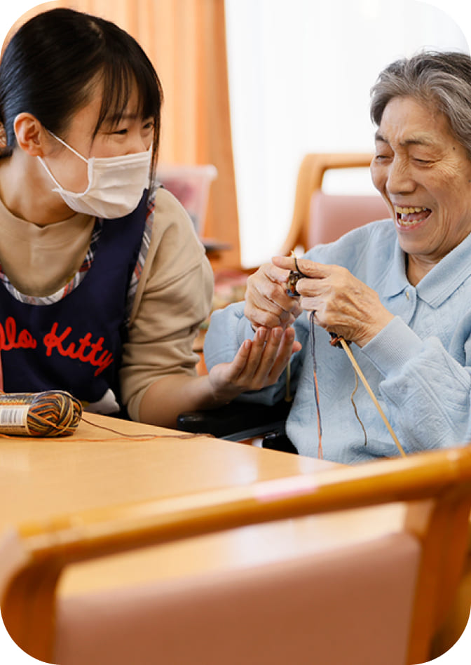 笑顔でお話しするおばあちゃんと介護士